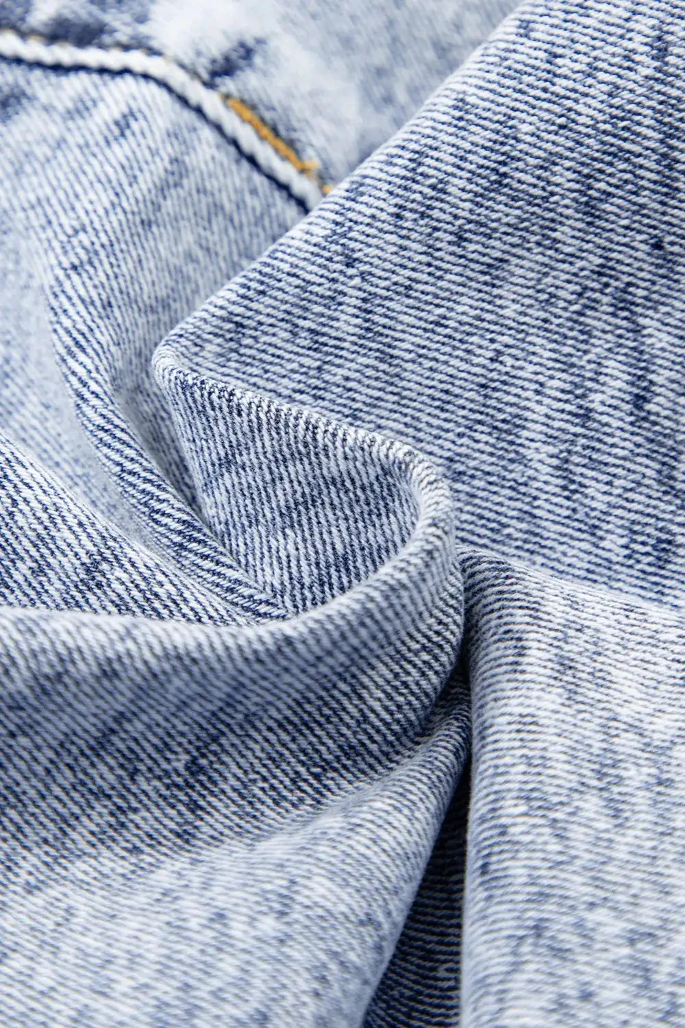 Women high waist rhinestone light-wash denim shorts; close-up of blue denim fabric texture