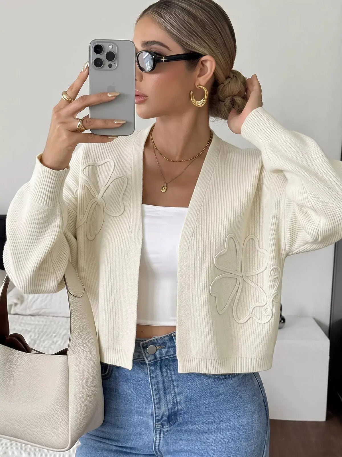 Four-Leaf Clover open-front cardigan in cream knit with embroidered clover motifs.