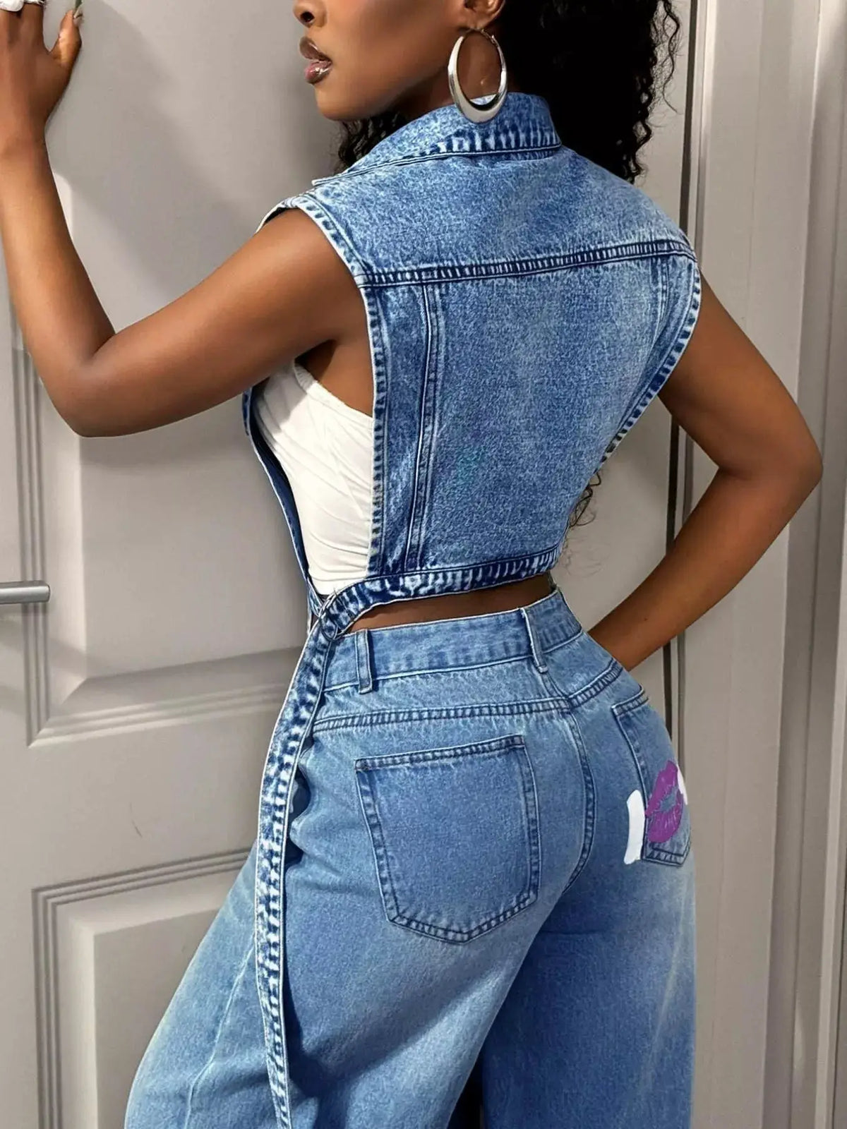 Open-front blue denim vest with vintage wash and pockets, cropped sleeveless design.