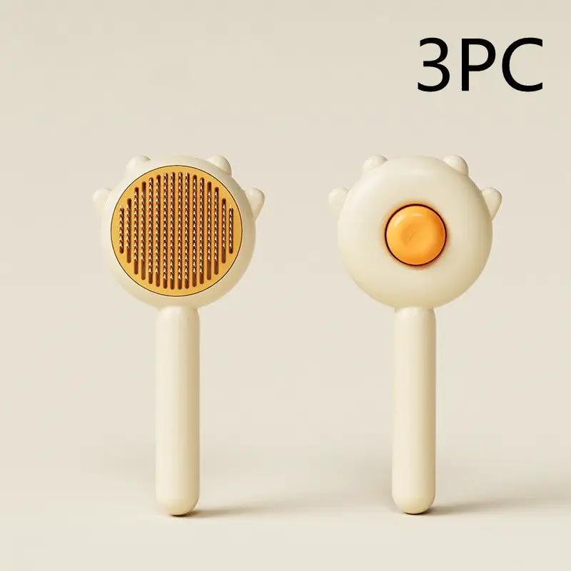 3-piece cat and dog grooming comb set; cream handheld massagers with gold teeth and orange button