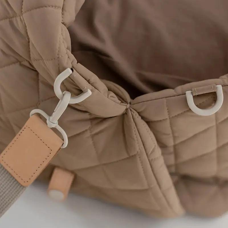 Pet handbag for cats, quilted tan fabric with white D-rings and beige leather patch.