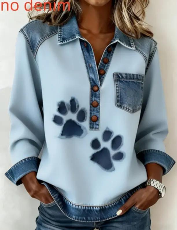 Denim long-sleeve top by AdTec; light blue body with dark denim collar and pocket, brown button placket, and paw print graphics.