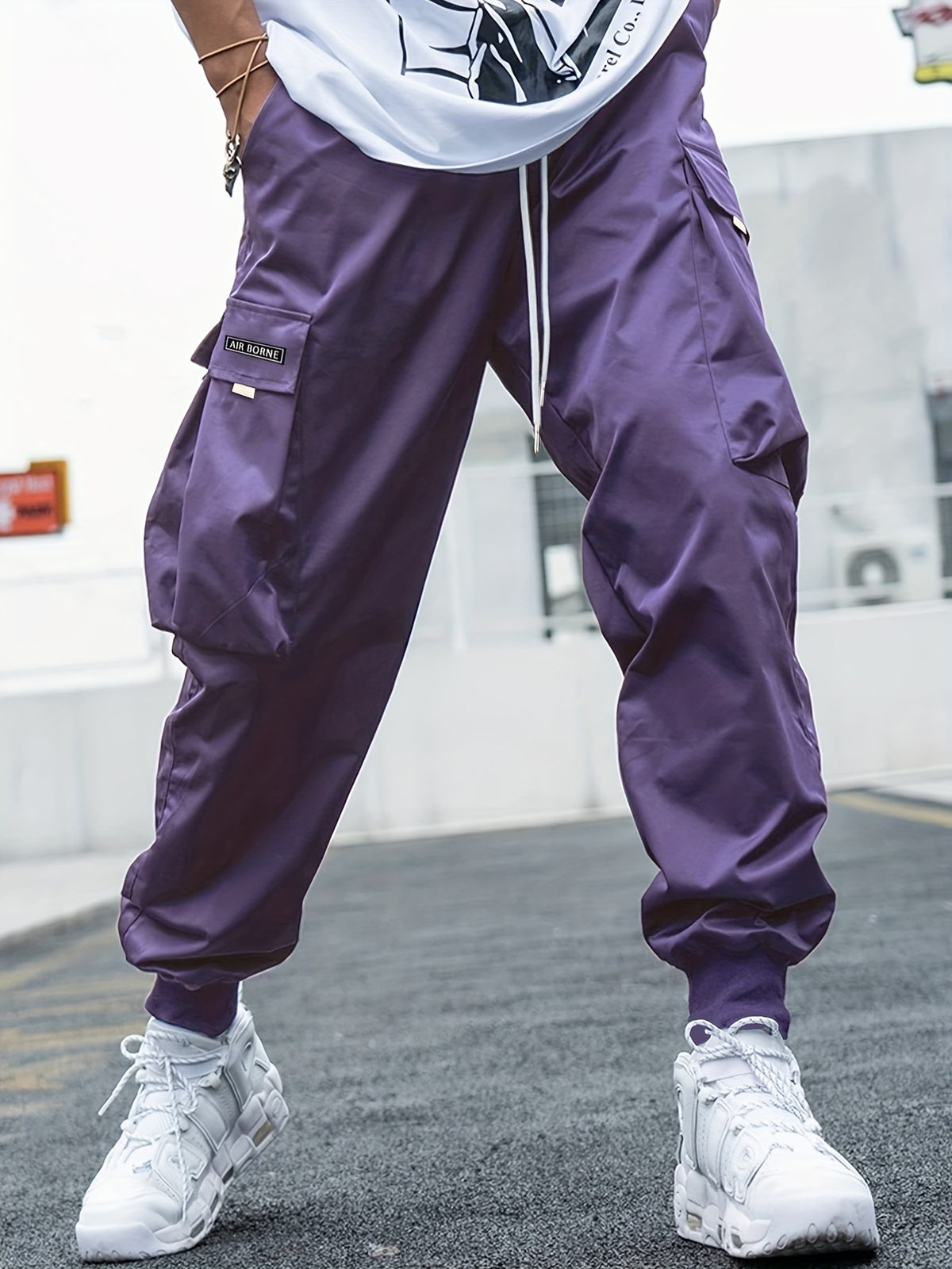 Men's purple multi-pocket cargo pants with drawstring waist and Air Borne patch.