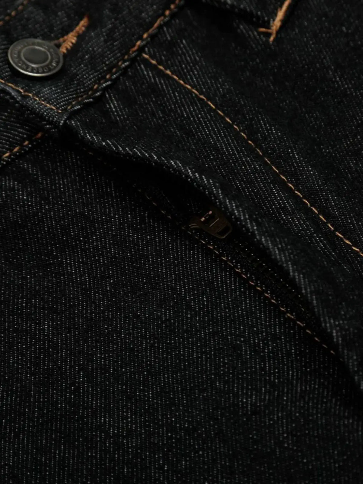 Men's wide-leg denim shorts fabric close-up showing orange topstitching and metal button