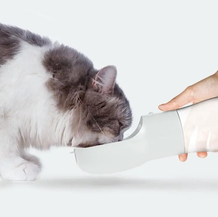 Traveling Out Portable Dog Water Dispenser by AdTec; white dispenser shown with a pet drinking from the curved spout