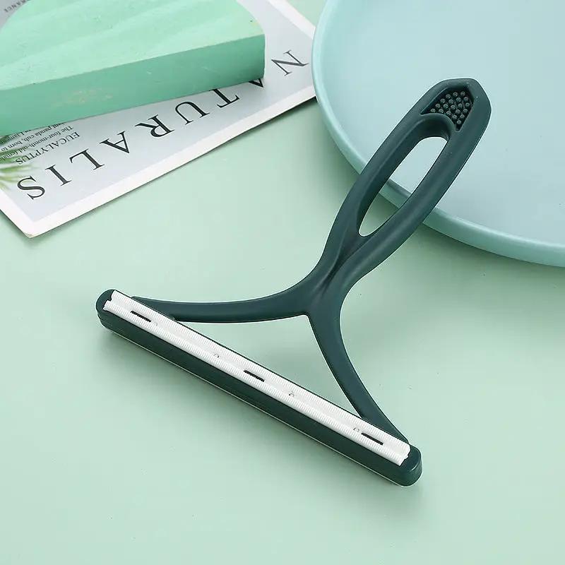 Silicone double-sided pet hair remover with teal ergonomic handle and white fabric-scraper strip for clothes and carpets