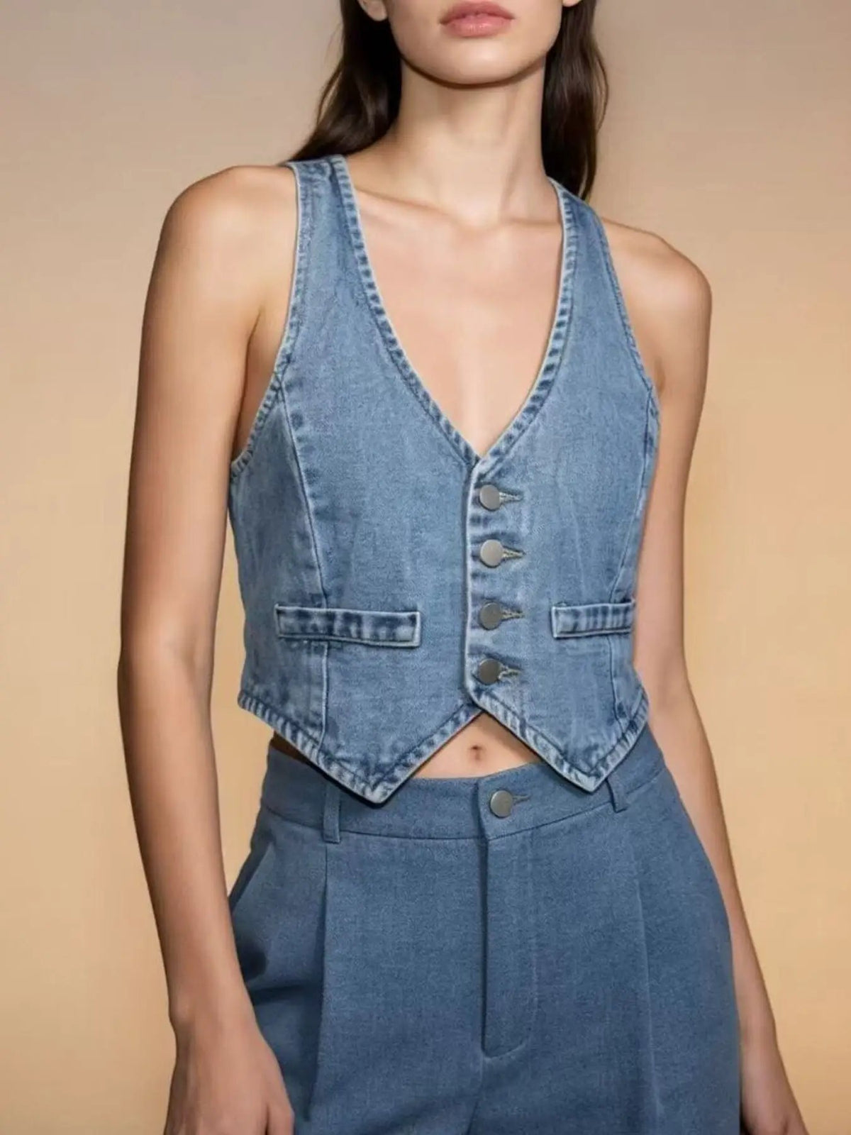 Denim vest with button-down front, cropped hem, V-neck, silver buttons, two front pockets, blue fabric