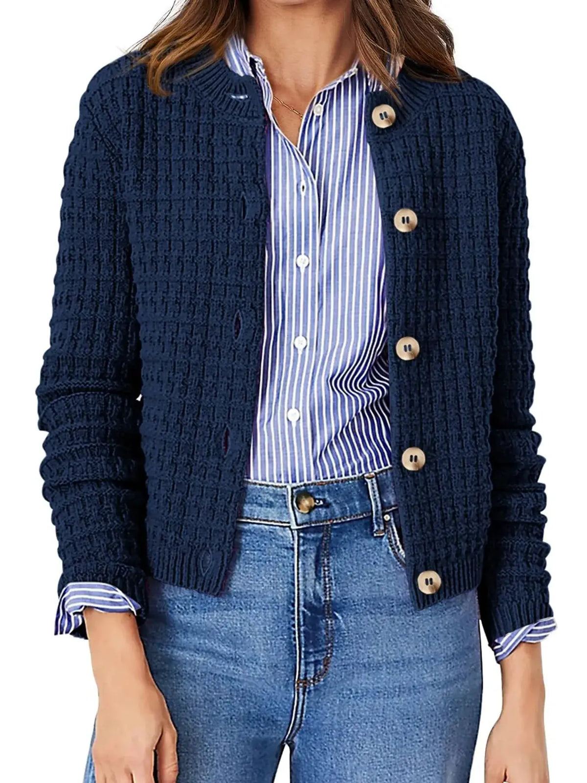 Textured navy knit cardigan with button-front closure worn over a blue striped shirt.