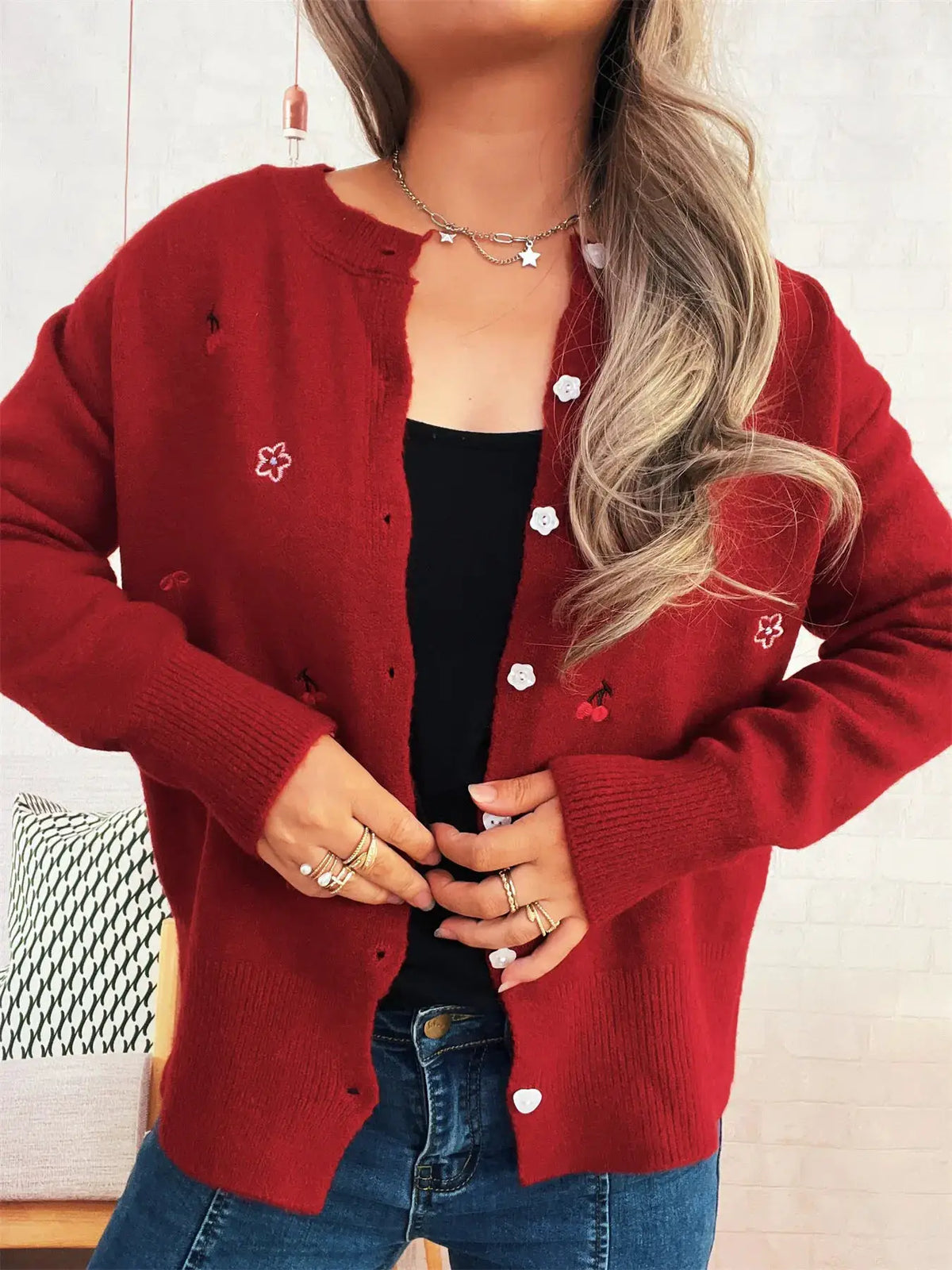 Red ribbed knit cardigan with button-front closure, white flower buttons and floral embroidery.