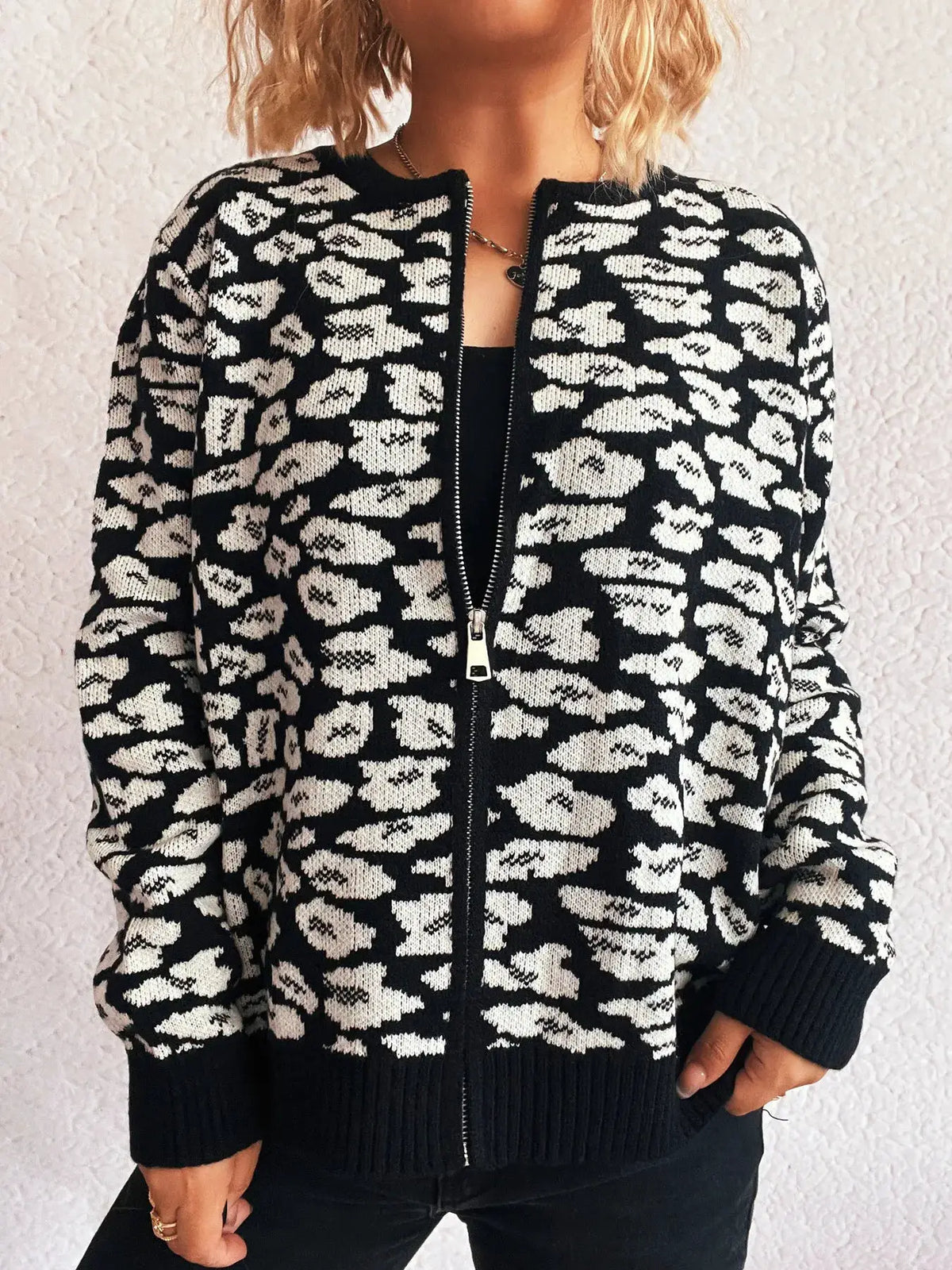 Zip-up cardigan in black and white leopard knit with front zipper and ribbed cuffs and hem