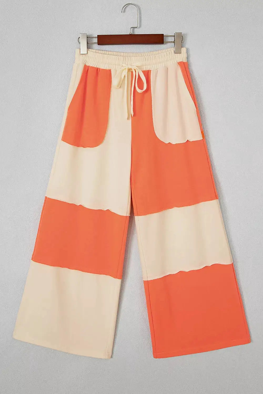 Raw seam colorblock wide-leg ankle-length pants in cream and orange with a drawstring elastic waist and relaxed fit