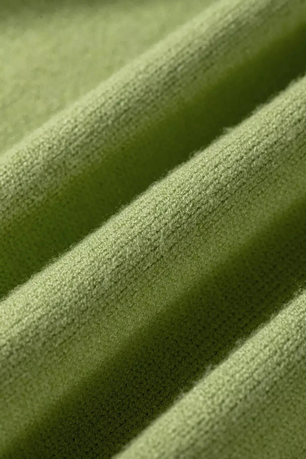 Fish graphic round-neck sweater green textured knit fabric close-up