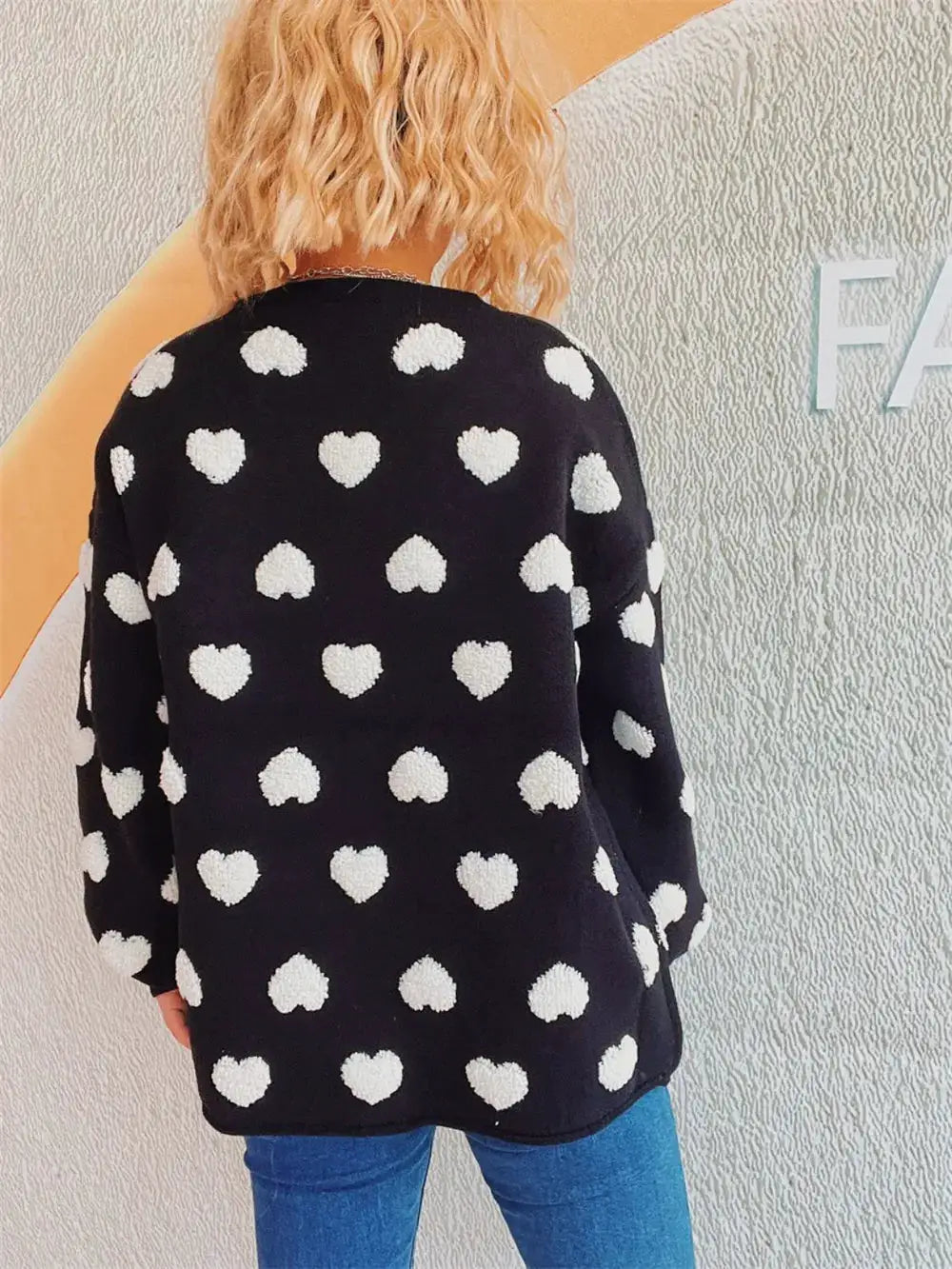 Cozy black heart-pattern knit cardigan with white heart accents, long sleeves, button front