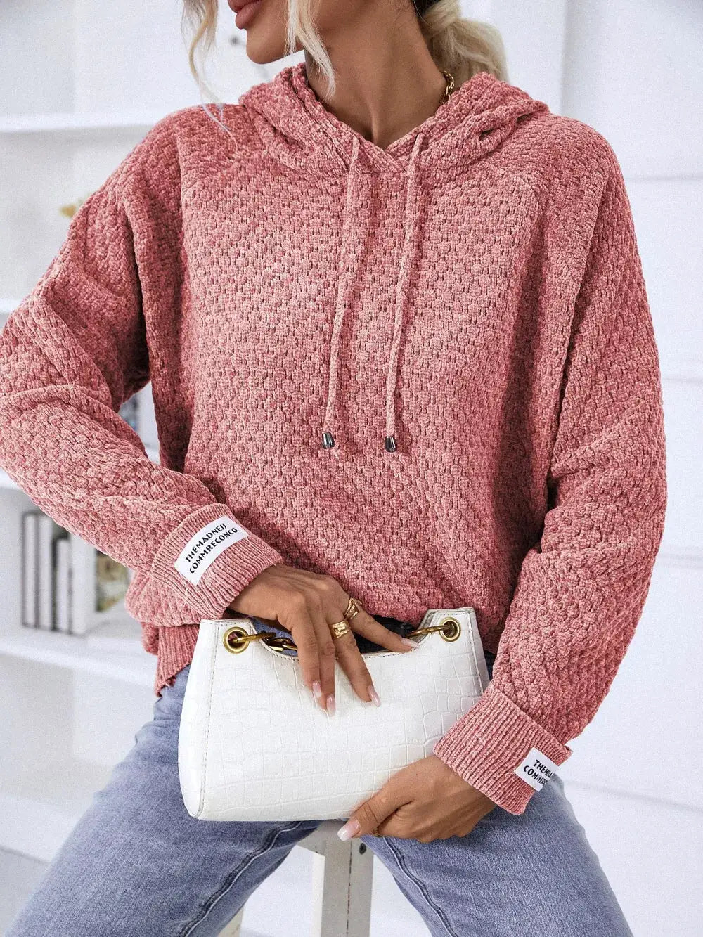 Textured pink hoodie sweater in premium polyester, Trendsi; paired with a white handbag.