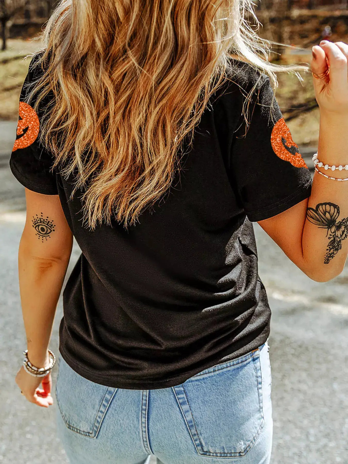 Glittering pumpkin face crewneck Halloween T-shirt, black with orange glitter pumpkin graphics on sleeves
