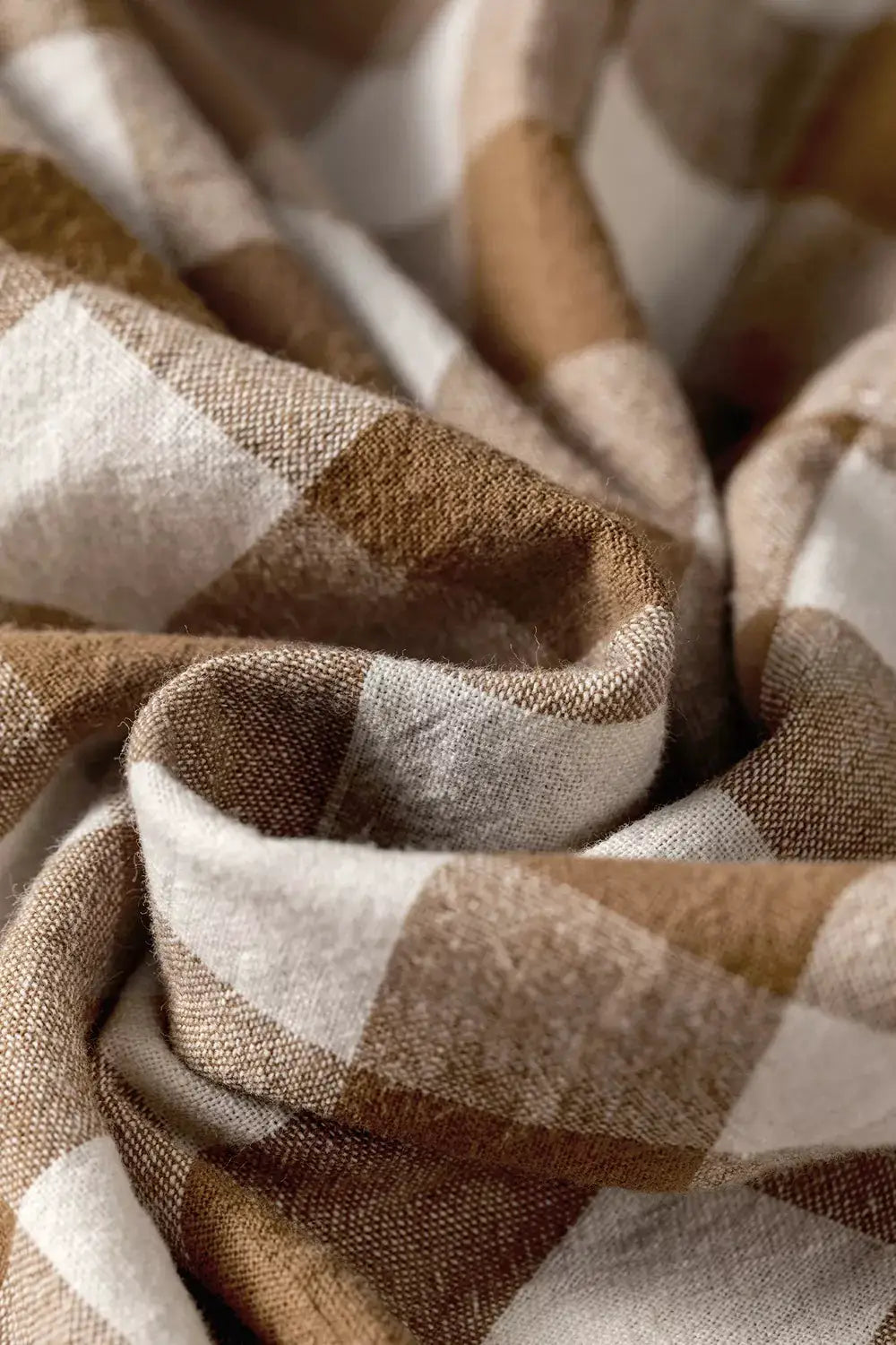 Gingham plaid trousers fabric close-up in brown and white