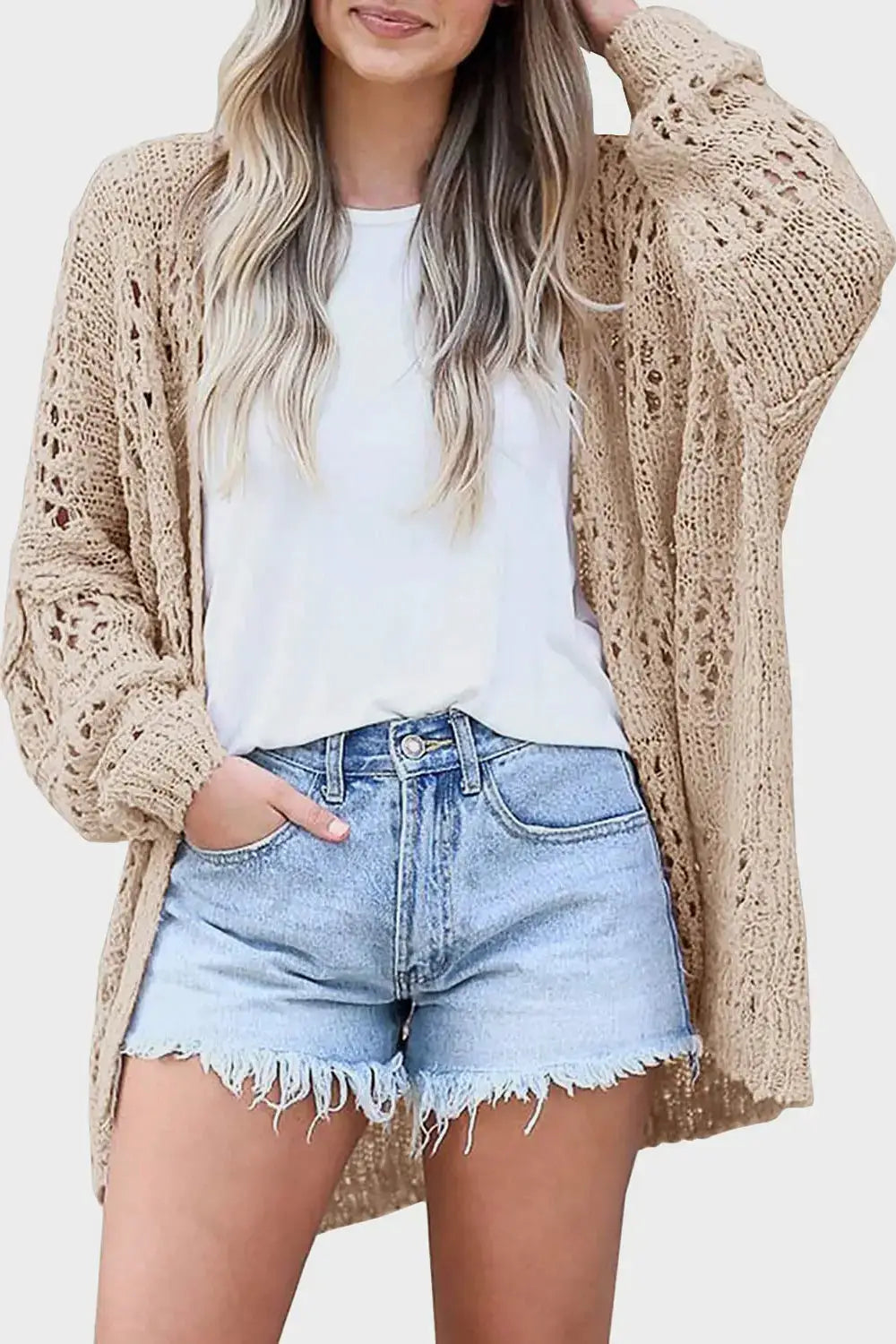 Openwork open-front long-sleeve acrylic cardigan in tan, worn over a white tee and denim shorts, cozy knit texture