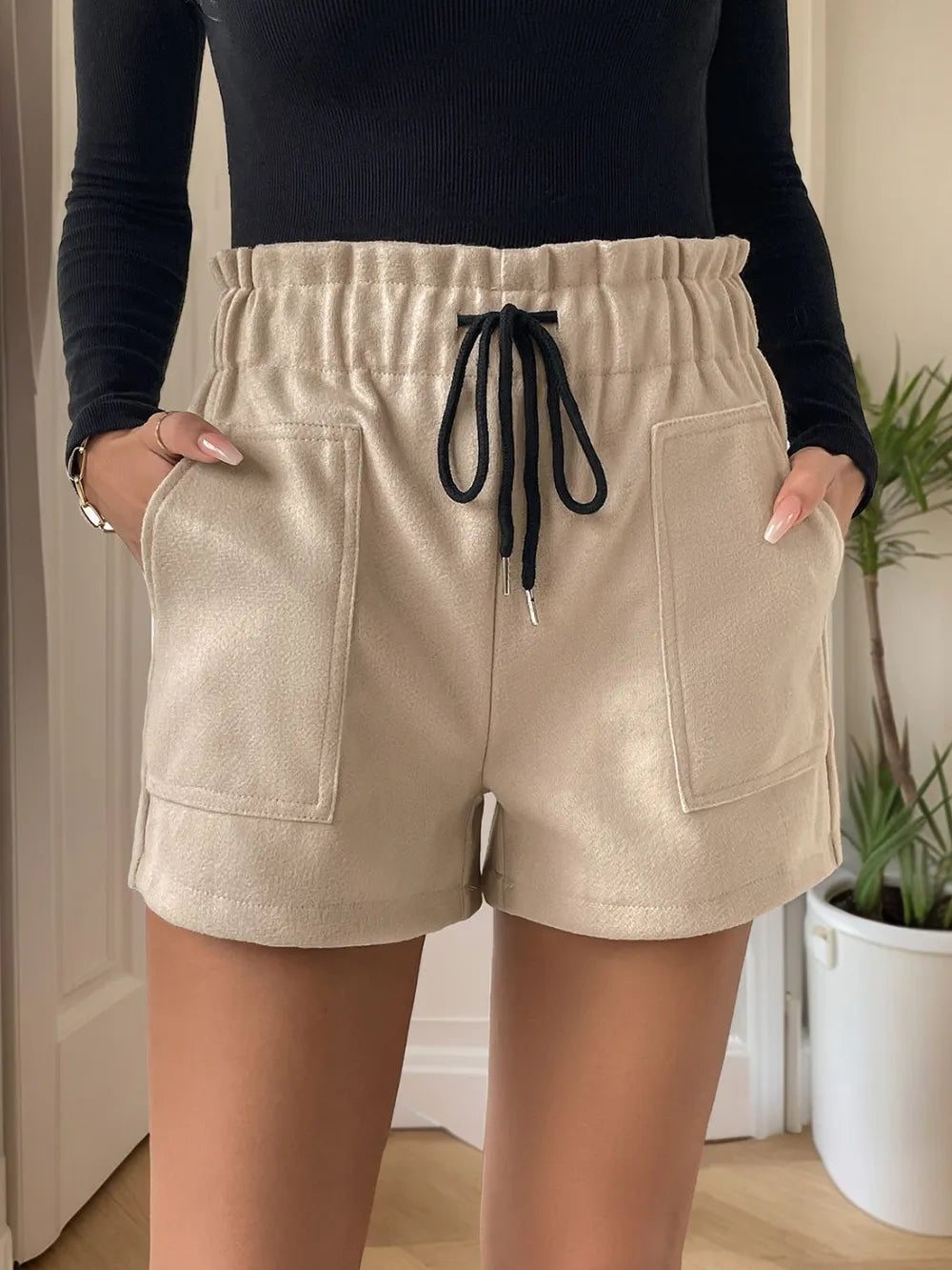 Perfee Frill Drawstring Shorts with Pockets by Trendsi, beige shorts with front patch pockets and black drawstring.
