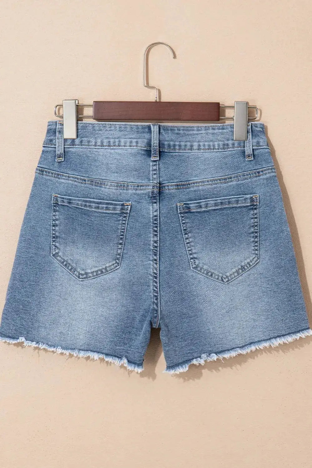 Denim shorts, light-wash cotton blend, back view with frayed raw hem and pockets