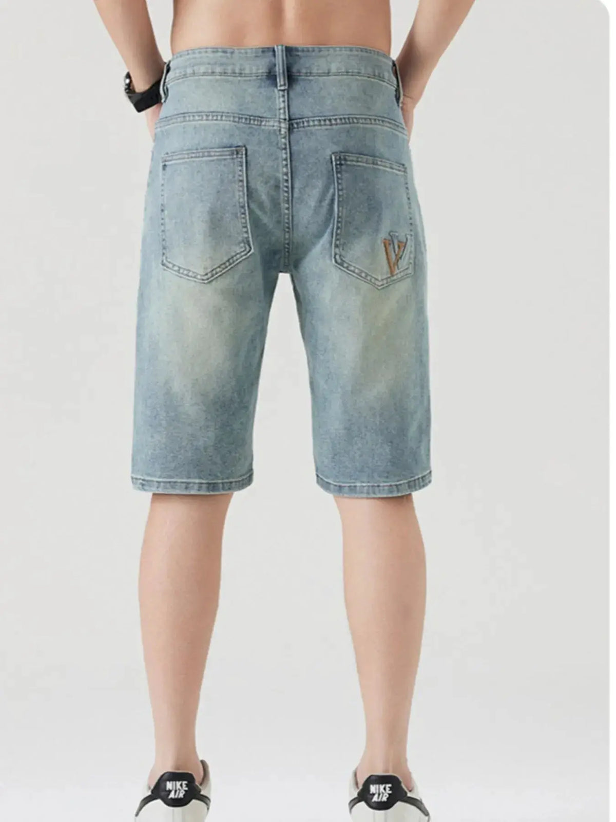 Men's casual stretch denim shorts with large back pockets; light wash blue denim, paired with Nike sneakers