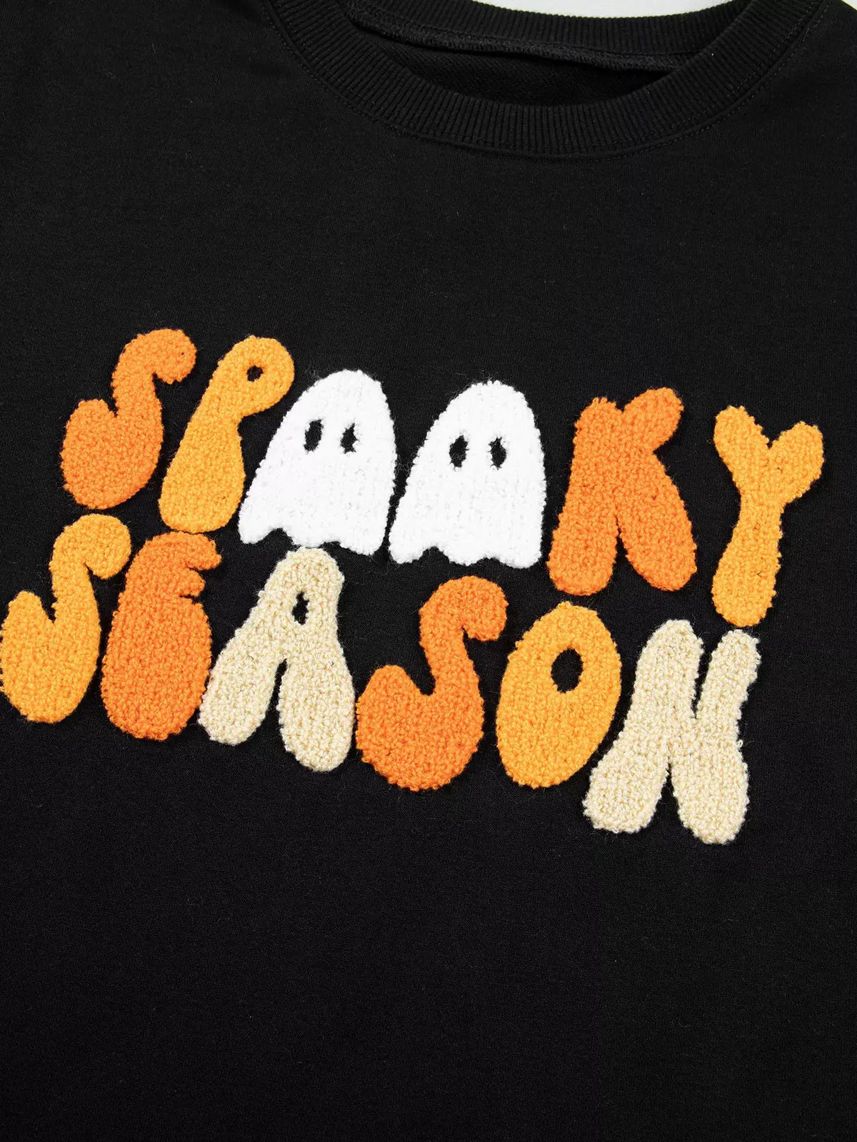 Embroidered spooky season long-sleeve sweatshirt on black fabric with orange and white ghost lettering