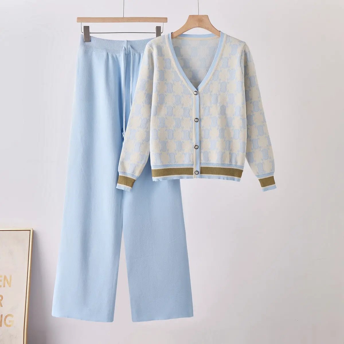 Two-piece knit set: light-blue cardigan with pale check pattern, brown trim, and matching wide-leg pants.