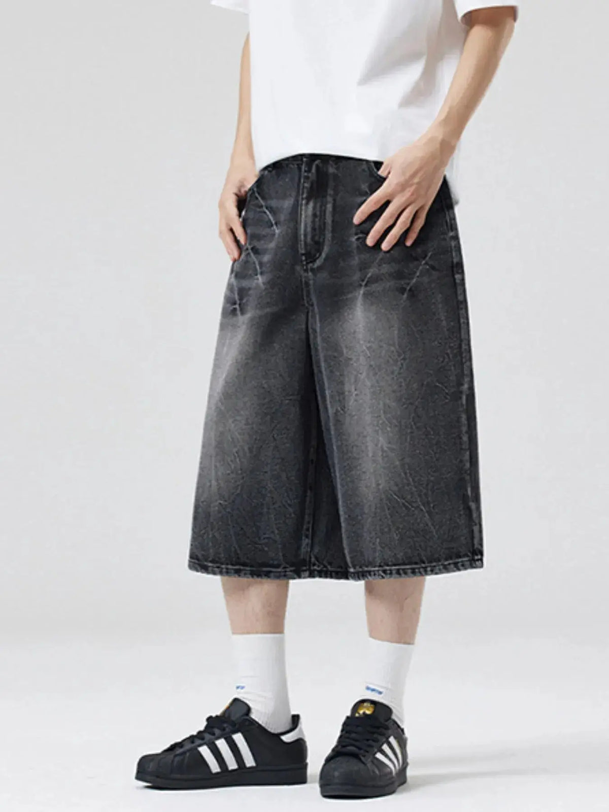 Men's oversized wide-leg distressed denim shorts with a faded black wash