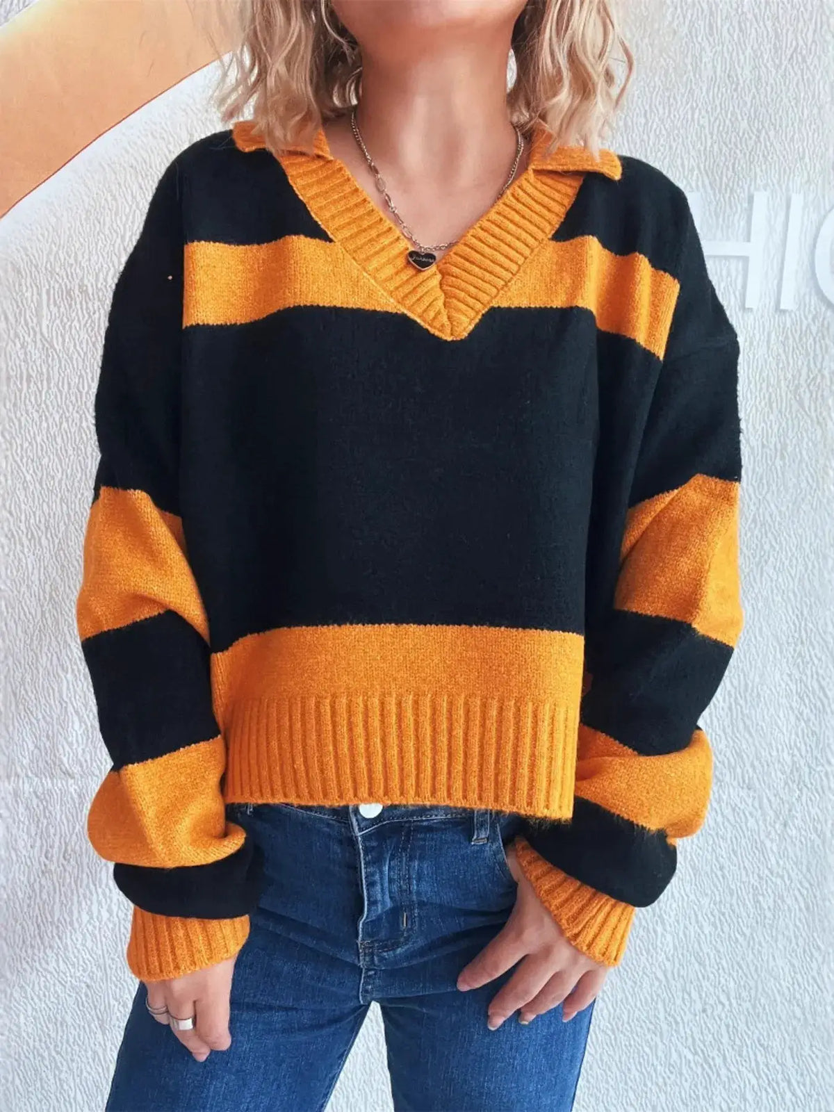 Color block long-sleeve sweater in black and orange with a soft stretch polyester blend and ribbed orange V-neck collar