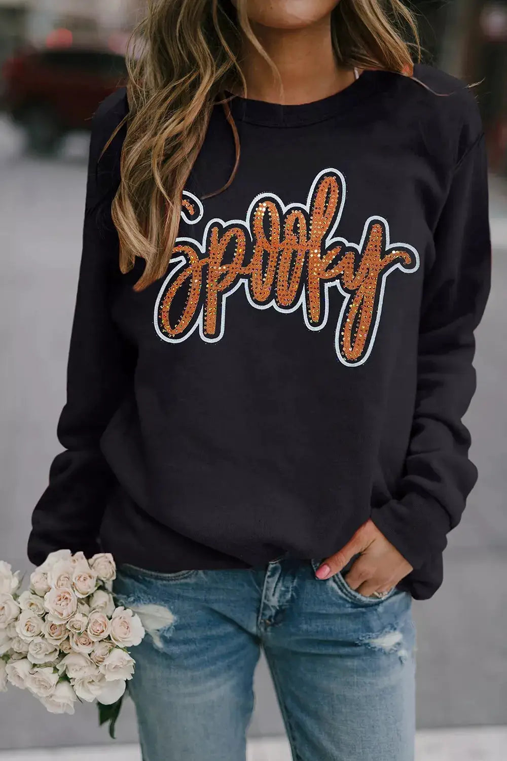Spooky Rhinestone Drop Shoulder Sweatshirt in black with orange rhinestone lettering by Trendsi.