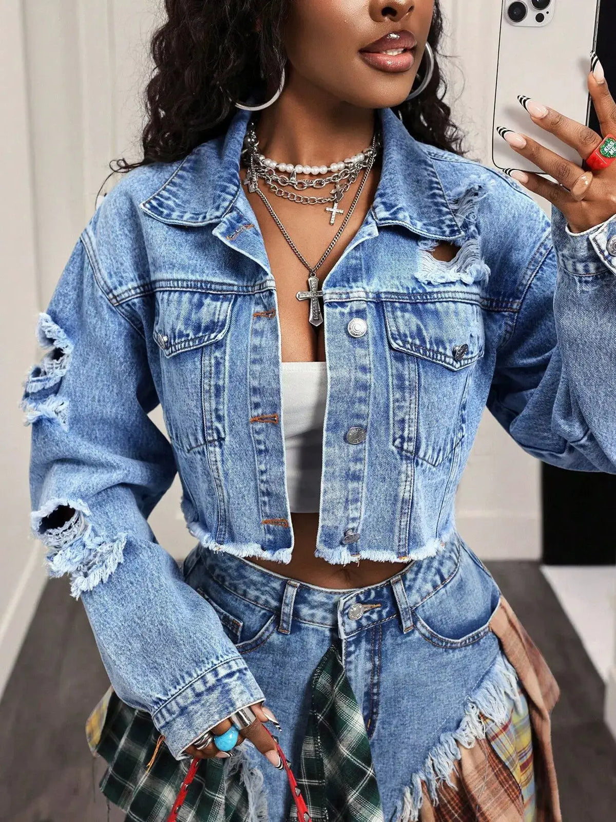 Distressed ruffled asymmetrical cropped denim jacket in light blue.
