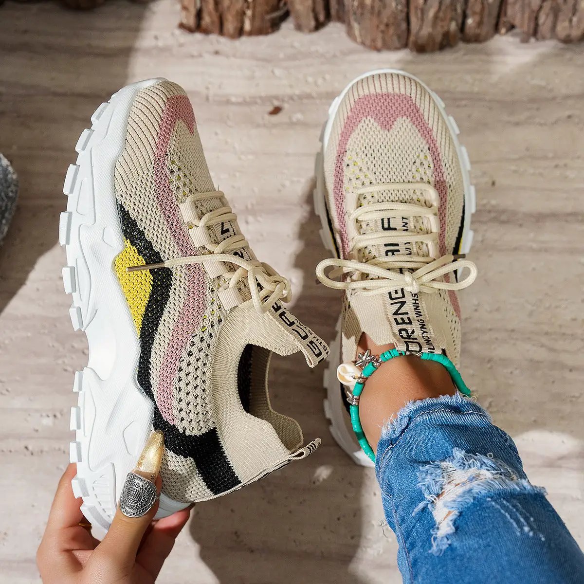 Pair of stylish lightweight women's casual sneakers in beige knit with pink accents and soft-bottom chunky white sole.