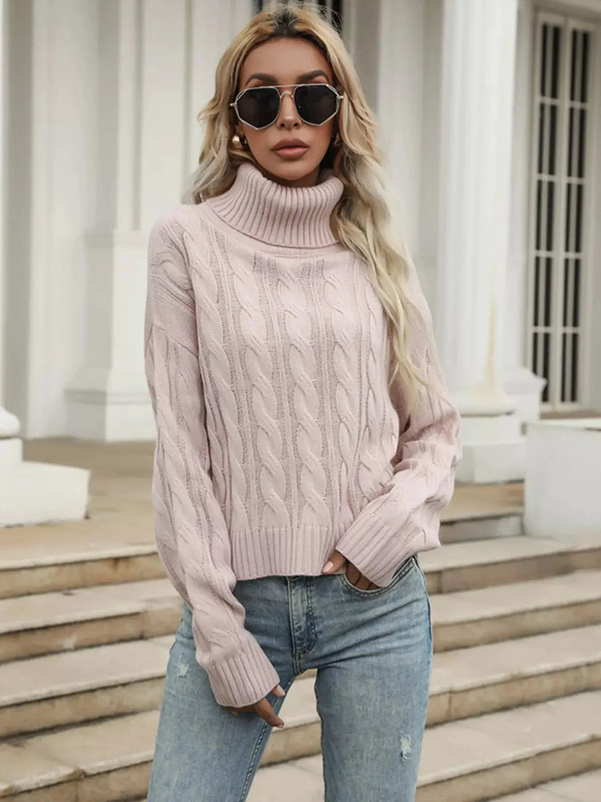 Cozy cable-knit turtleneck sweater in soft pink; stretchy pullover.