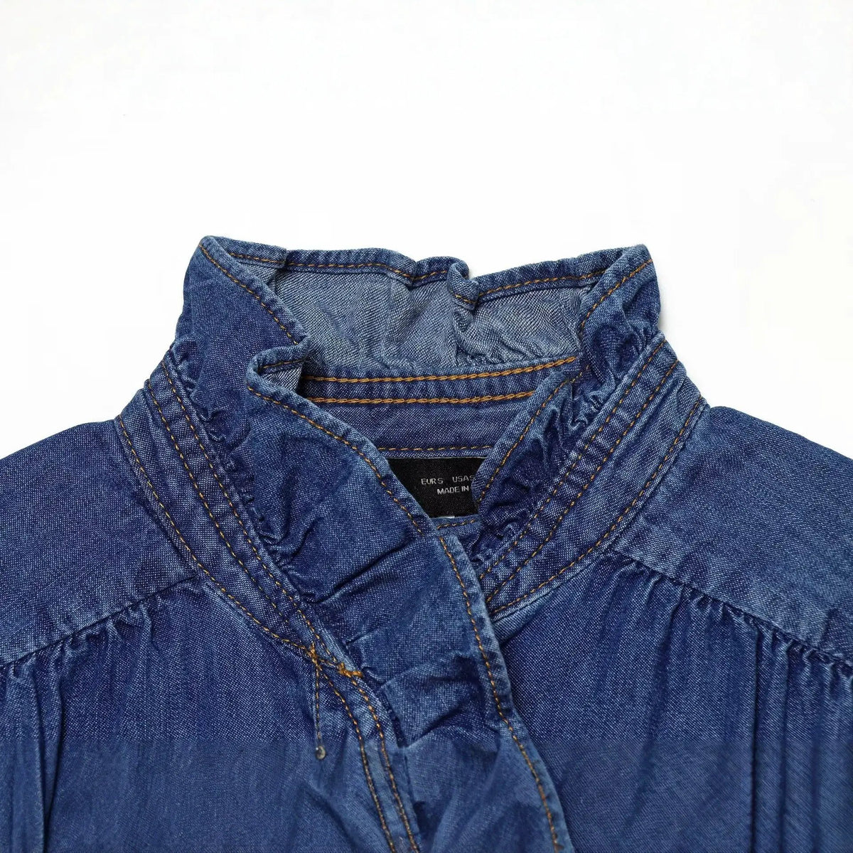 Casual blue denim shirt close-up of collar and front placket with yellow stitching