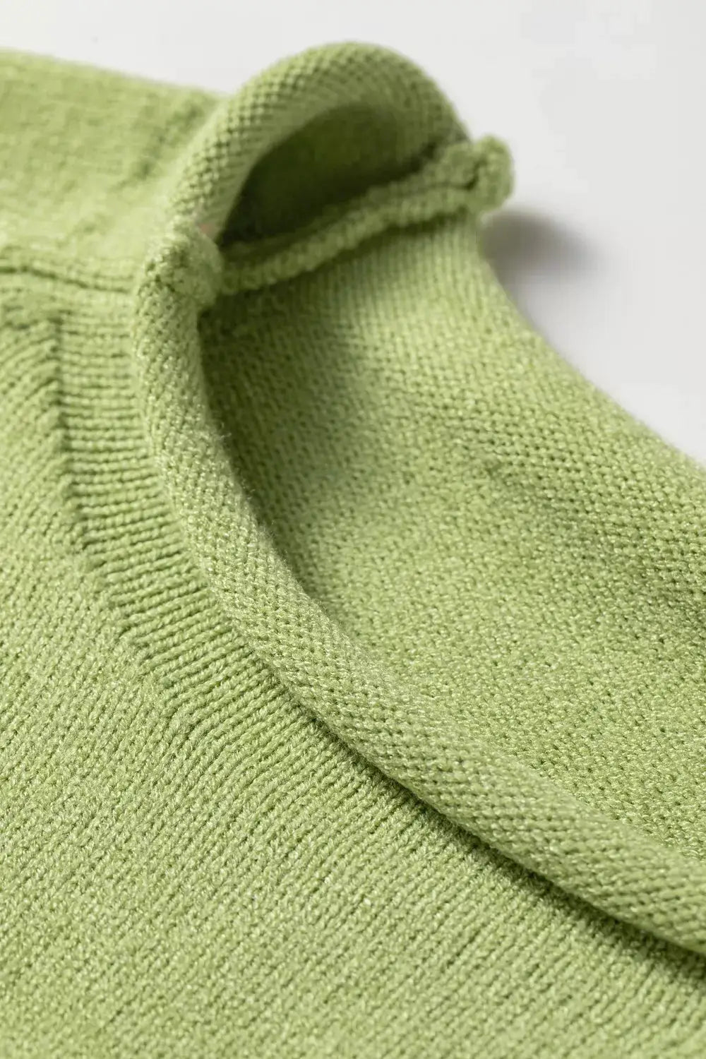 Sweater in green knit with round-neck, fabric close-up shows textured stitching