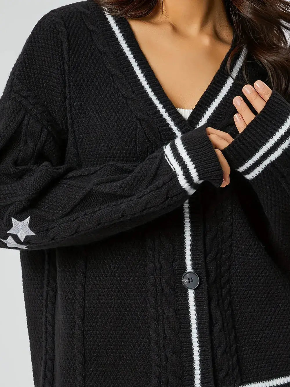 Womens black knit cardigan with V-neck, star embroidery on sleeve, white striped trim, button-front.