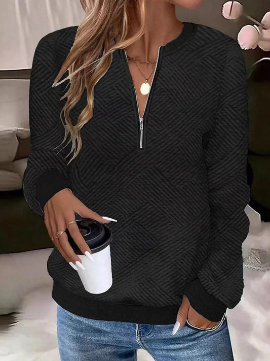 Textured black quarter-zip sweatshirt with diagonal chevron pattern and ribbed cuffs.