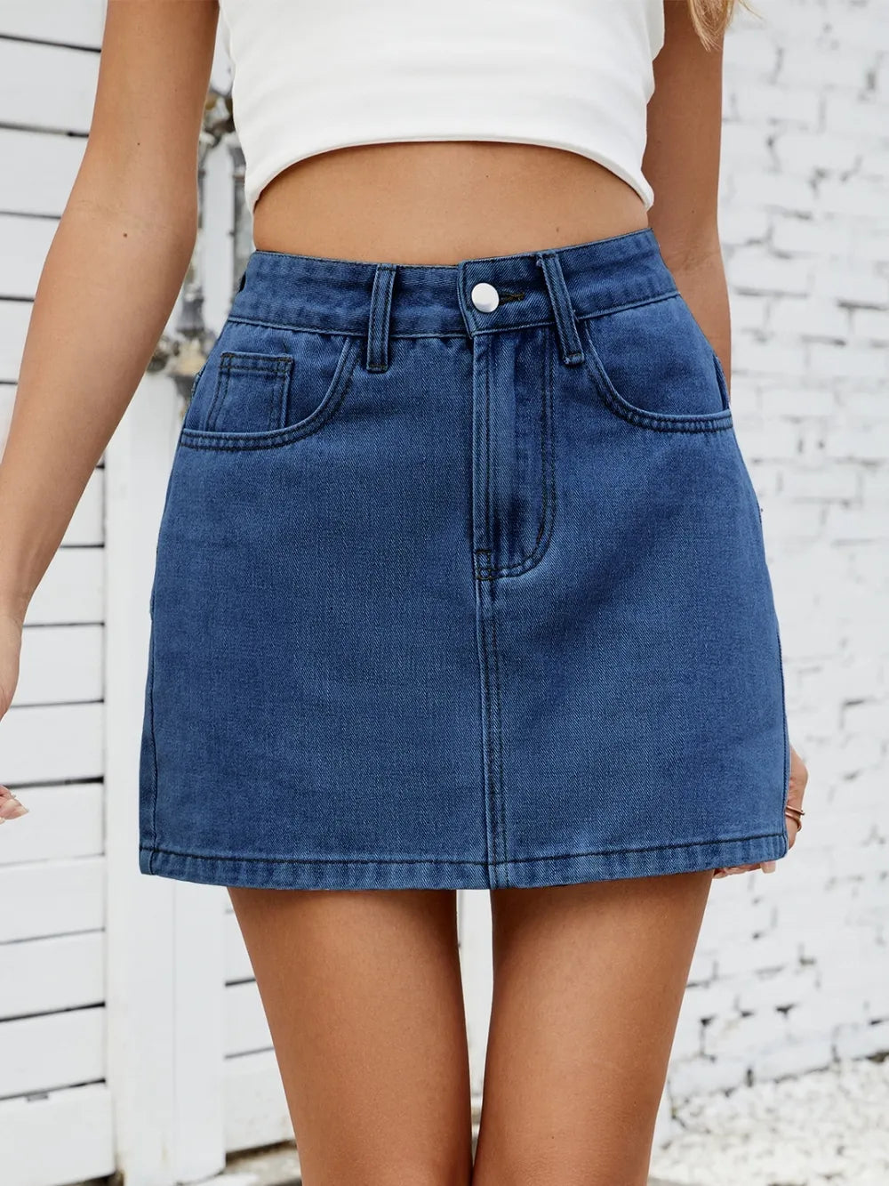 Solid mini denim skirt in blue, high-waisted with belt loops and front pockets by eprolo.