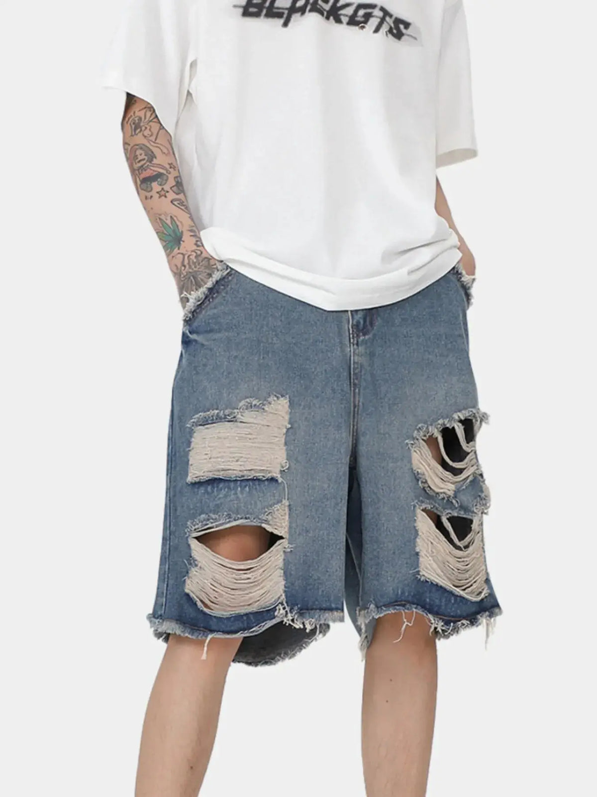 Men's oversized distressed denim shorts with stretch cotton pockets, blue denim with large ripped patches.
