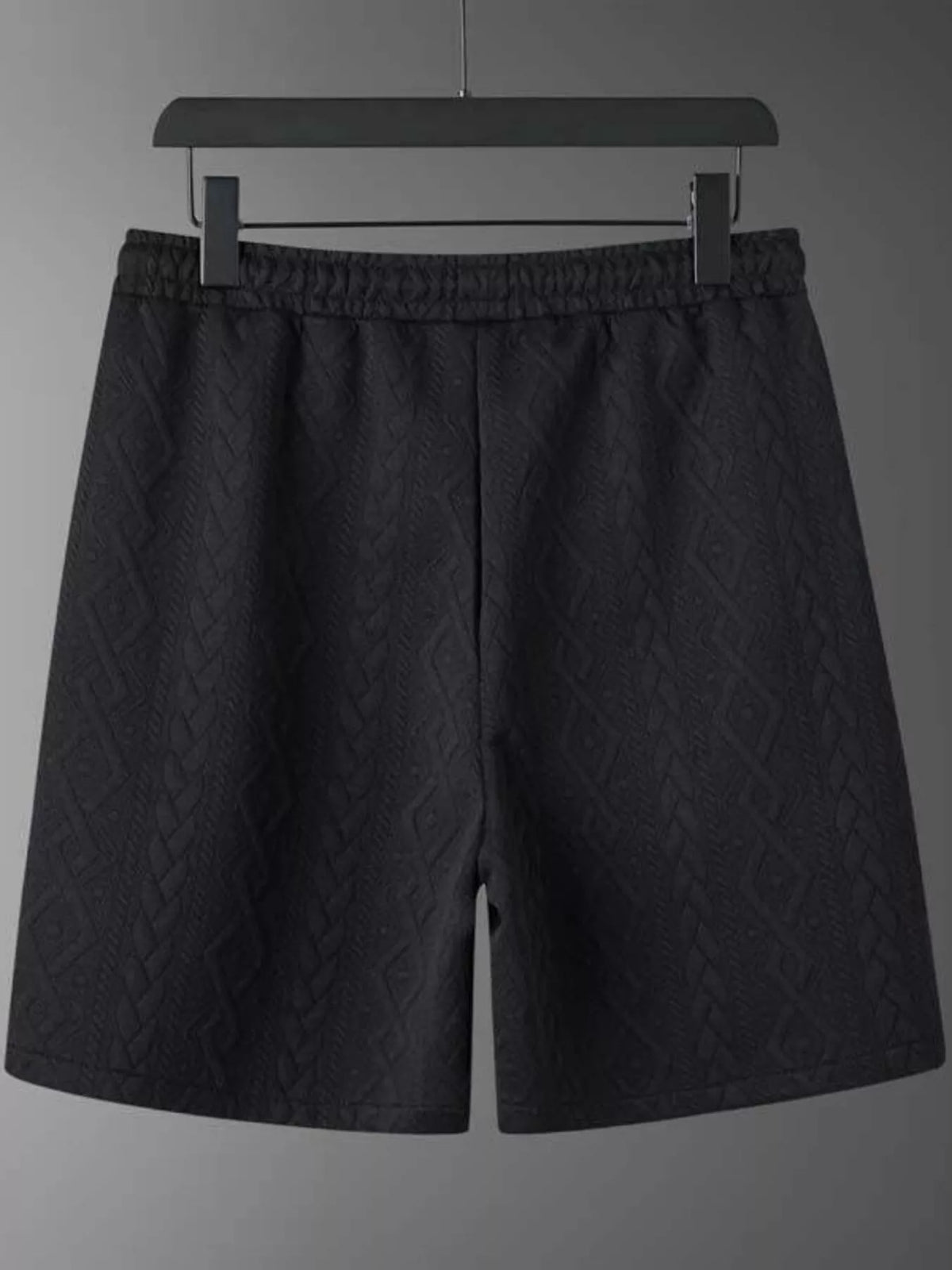 Men's black textured knit shorts with elastic waistband, diamond pattern, on hanger by Trendsi.