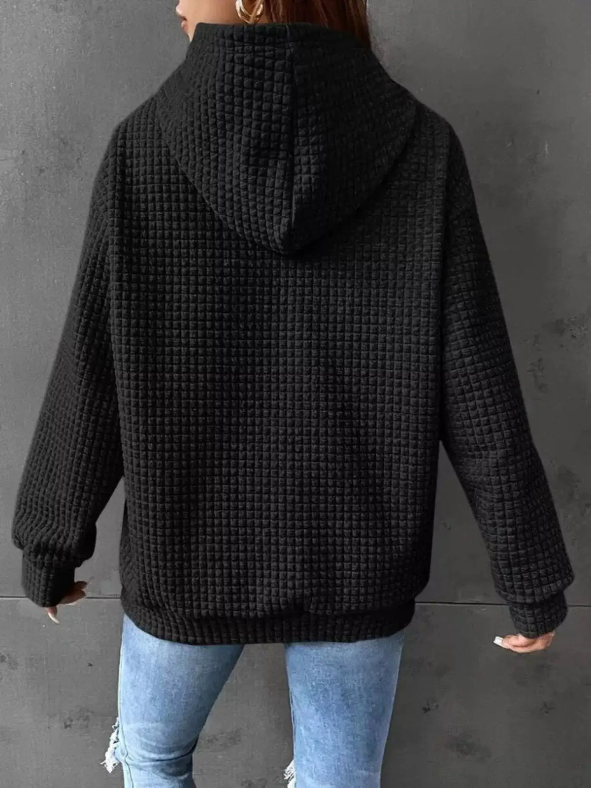 Hoodie, plus-size, black textured quilted fabric with hood, elastic hem and cuffed sleeves; back view.