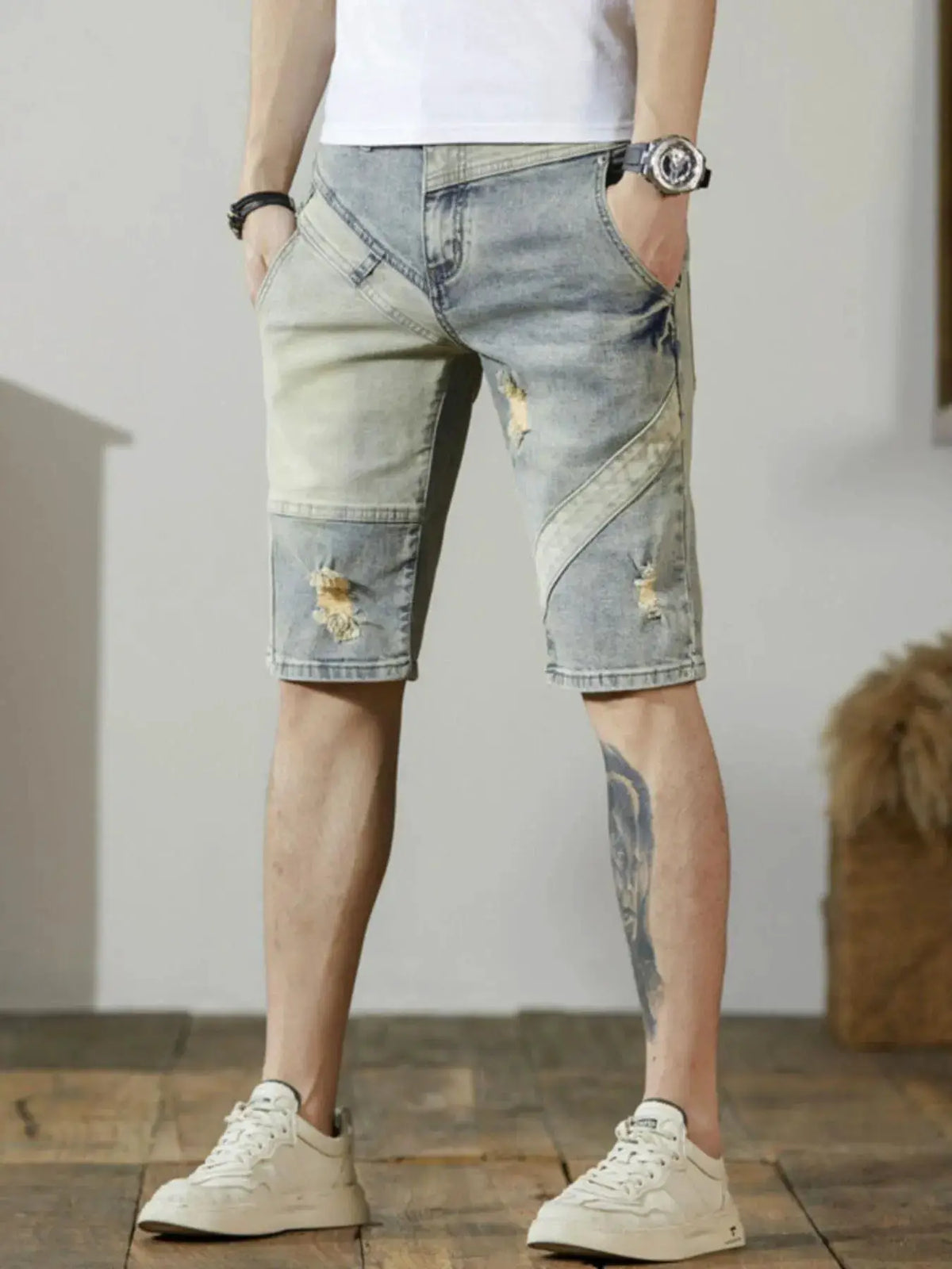 Men's relaxed stretch cotton denim shorts with distressed wash details; light blue with patchwork panels.