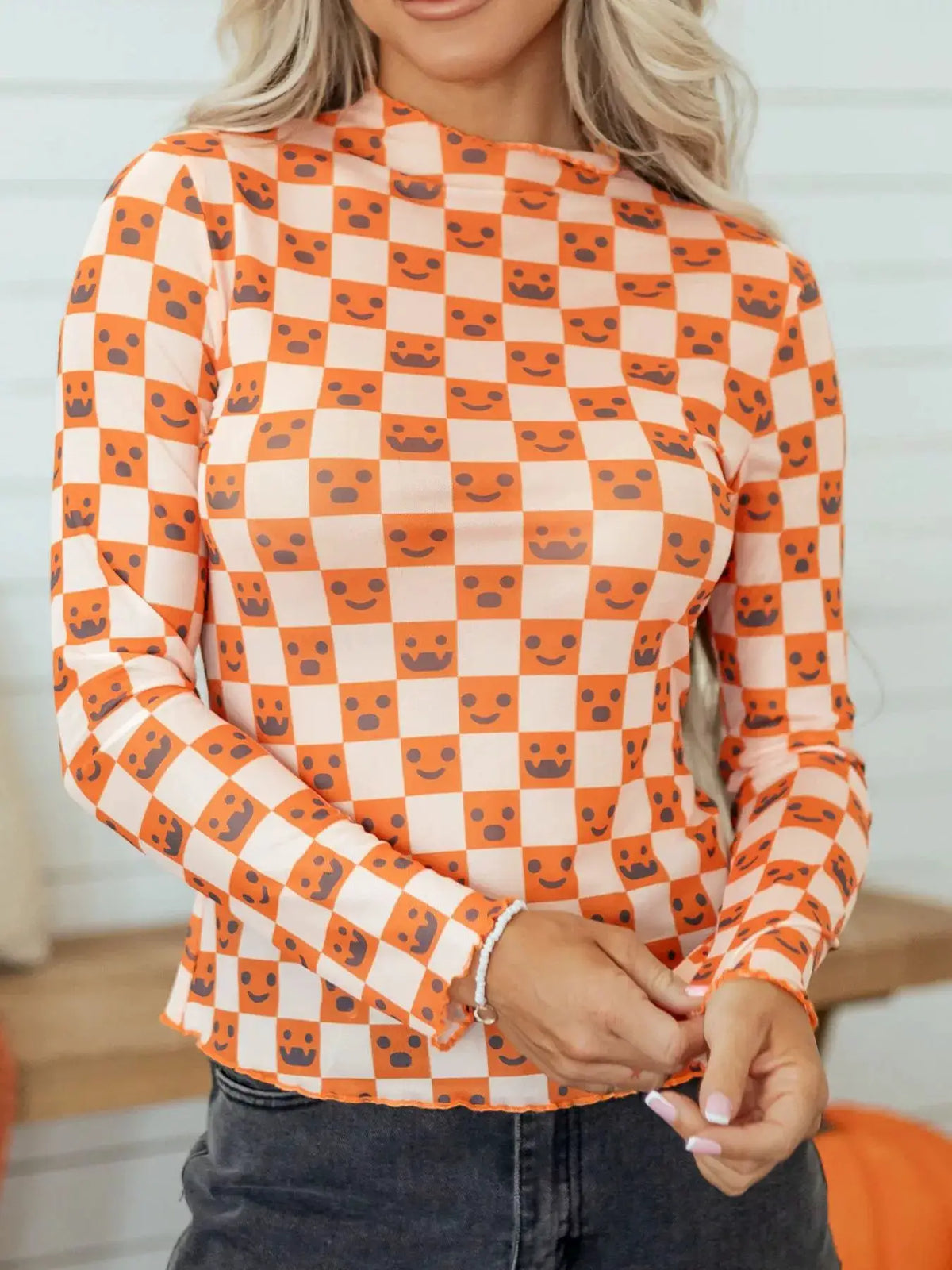 Abstract Halloween pattern long-sleeve mock-neck blouse in orange and cream checkered print