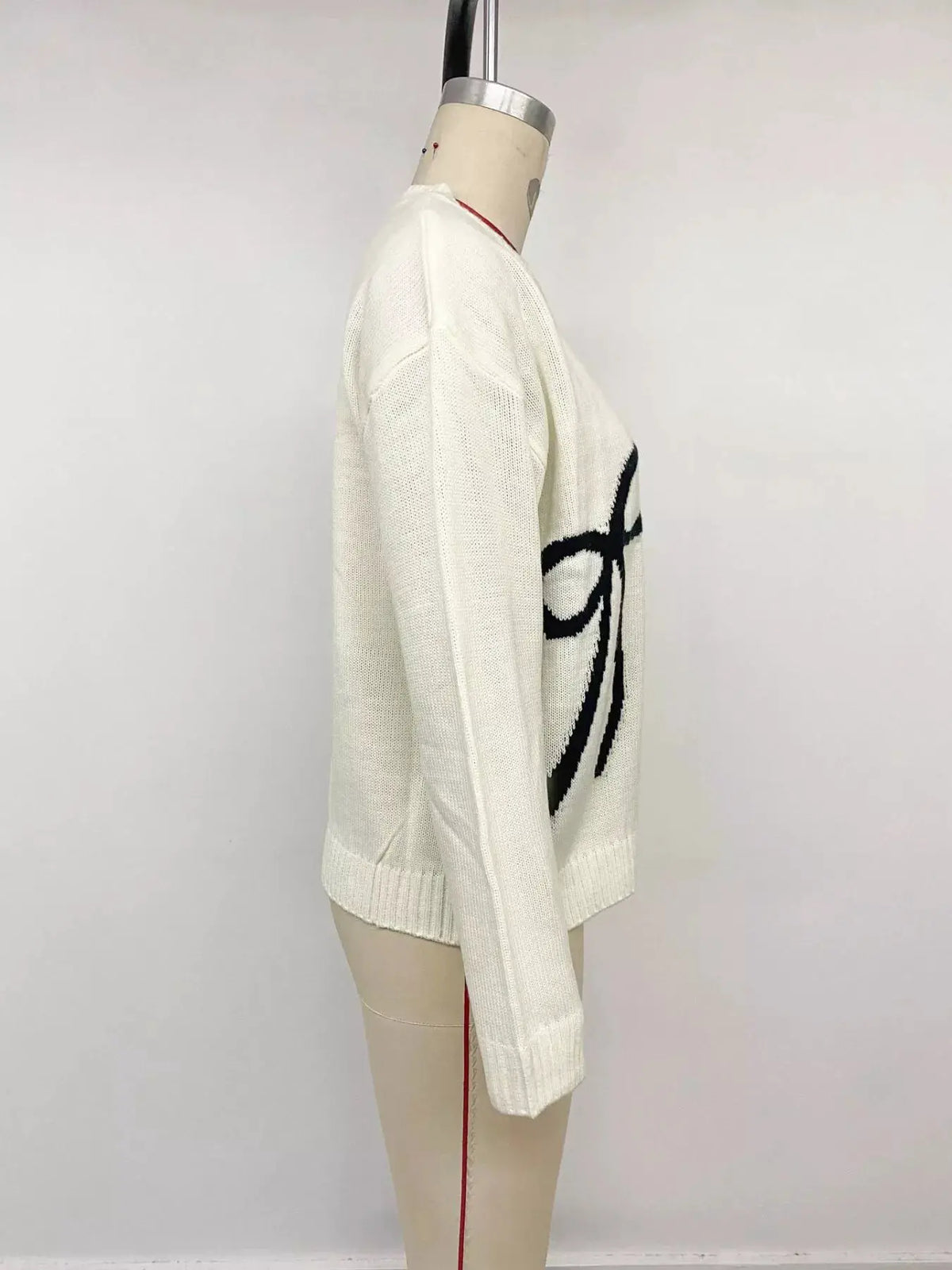 Bow graphic round-neck acrylic sweater in cream with soft stretch fit, displayed on a mannequin