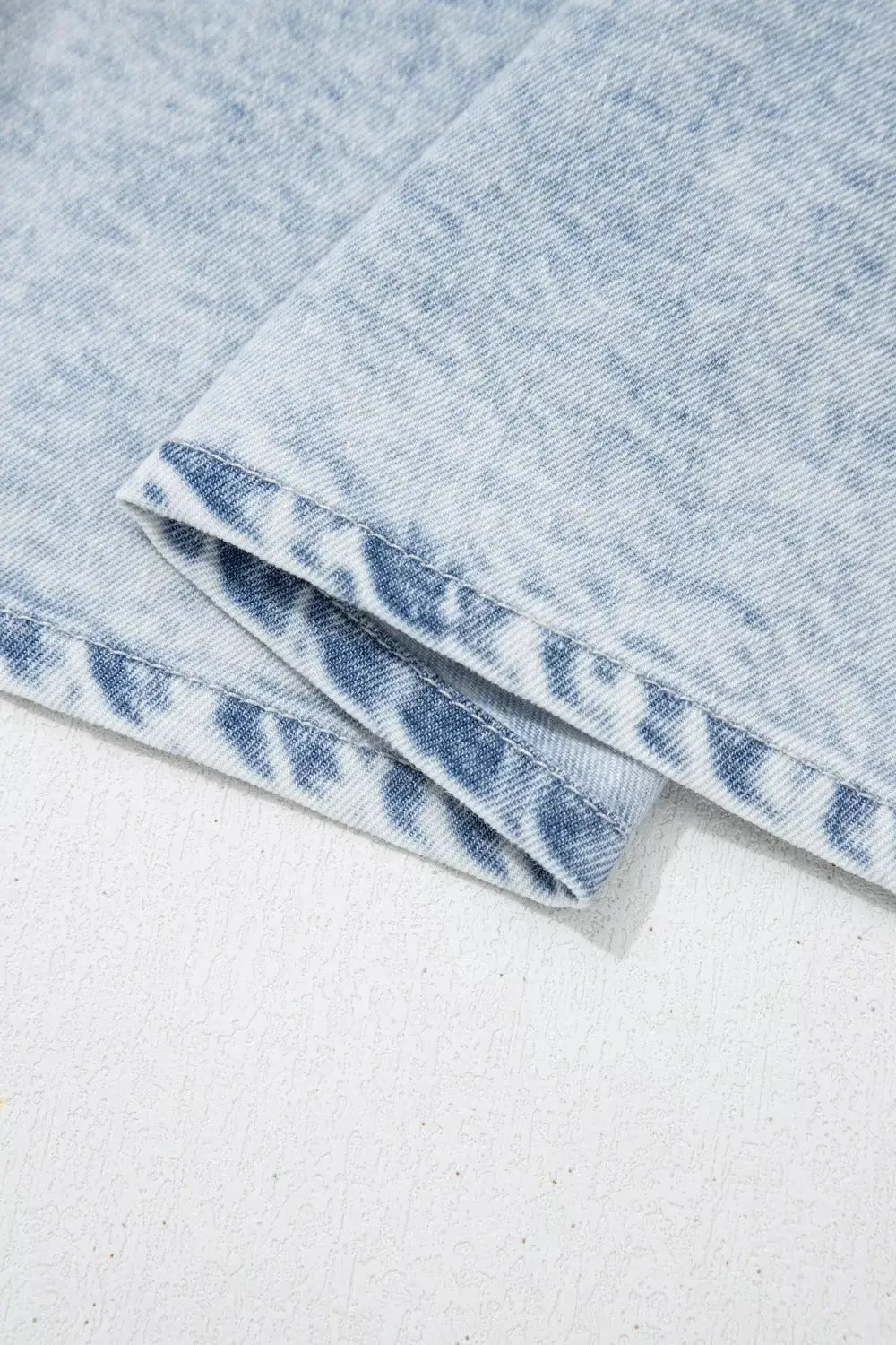 Vintage washed denim top with light blue fabric and folded hem detail.