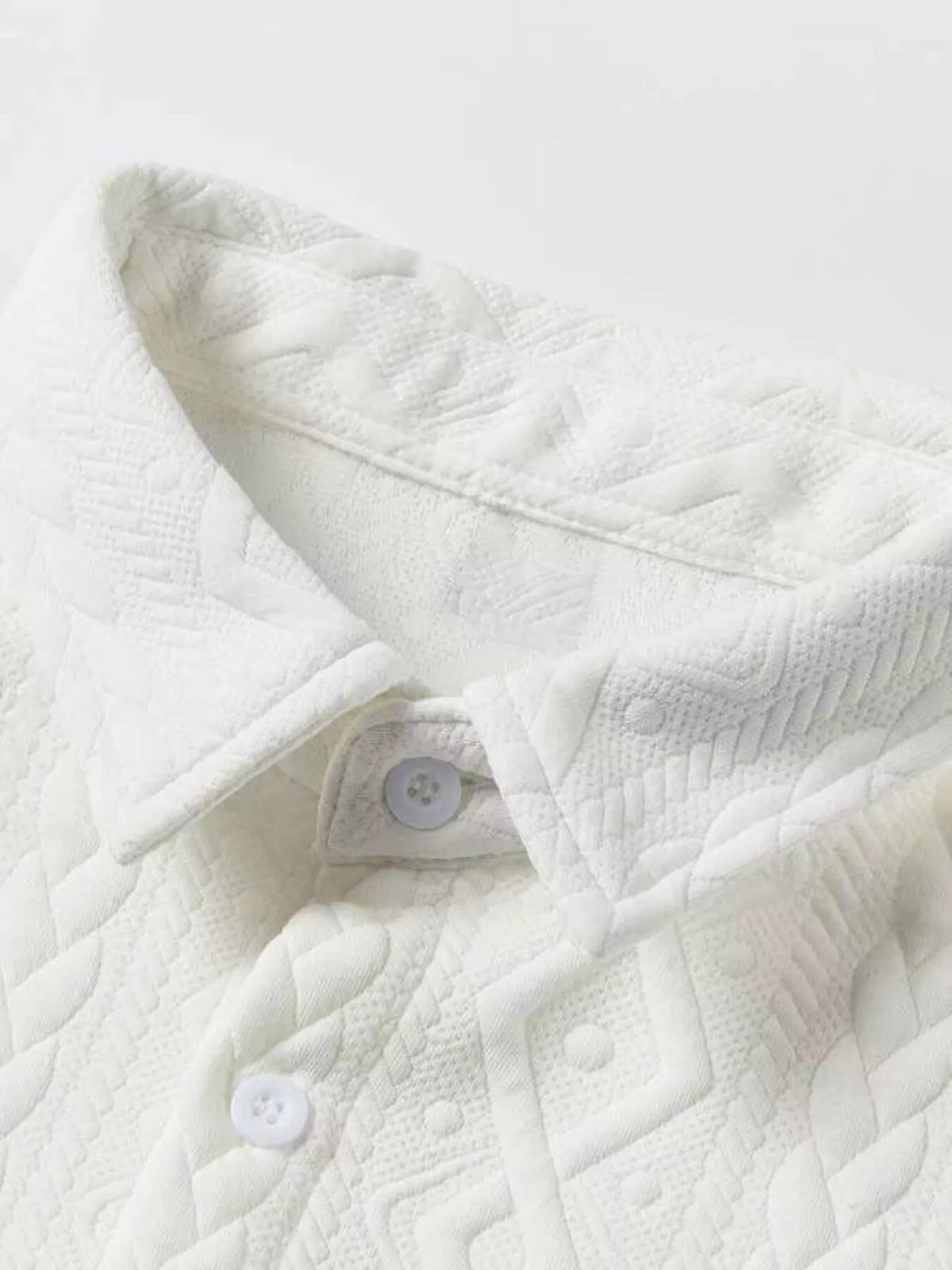 Men's white textured knit polo shirt with collar and buttons, close-up
