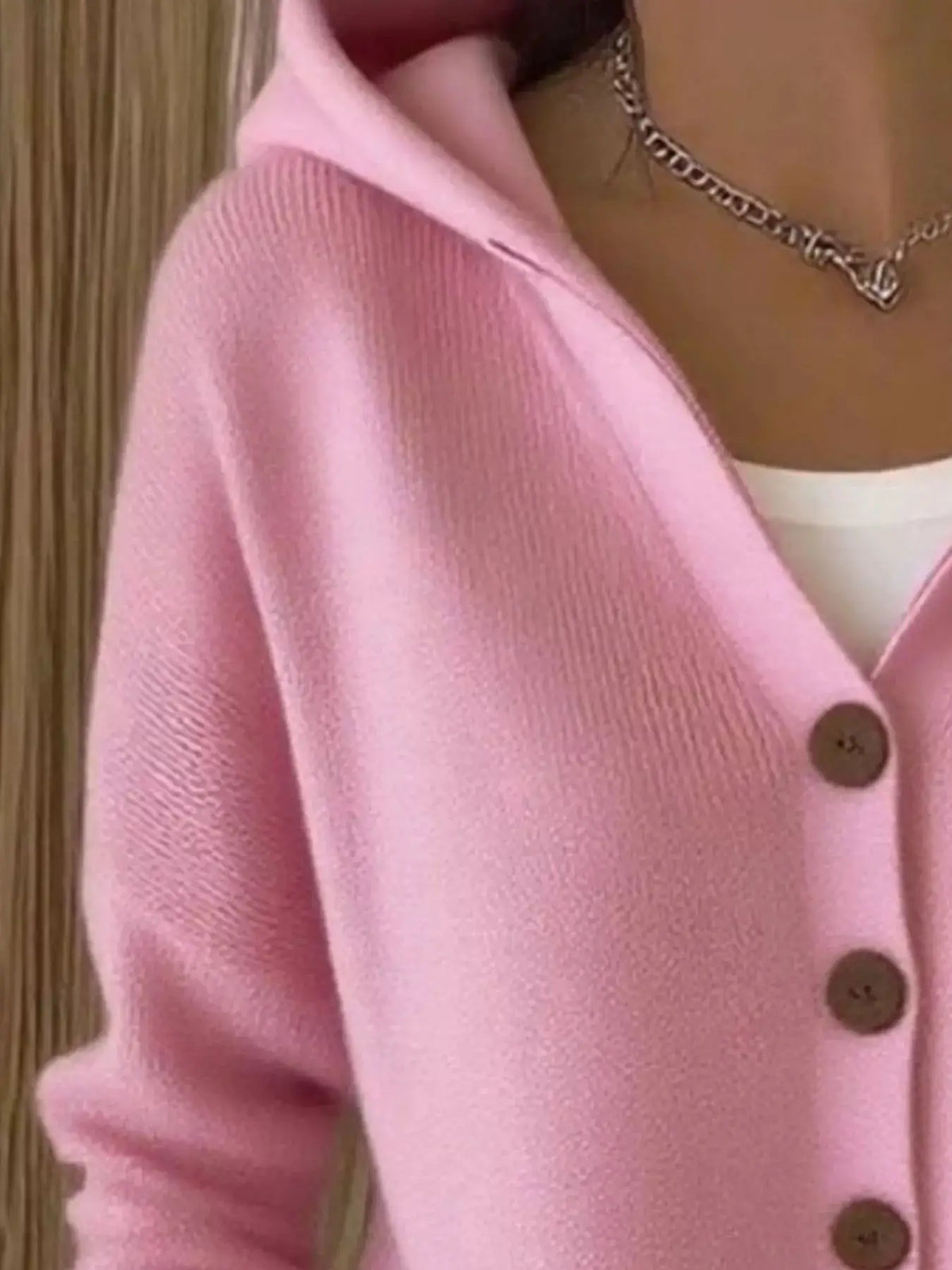 Pink knit cardigan with front brown buttons and soft textured fabric