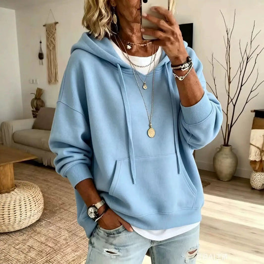 Womens loose-fitting light-blue hoodie with front pockets and drawstring hood, long sleeves.