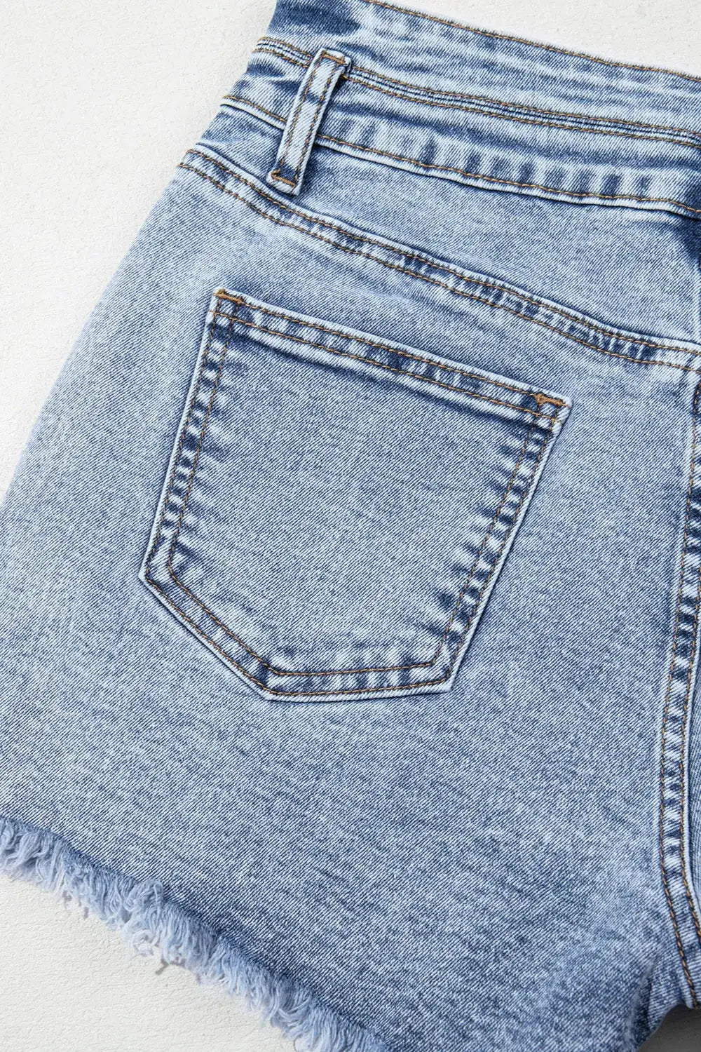 Women’s light-wash denim shorts with back pocket and raw frayed hem