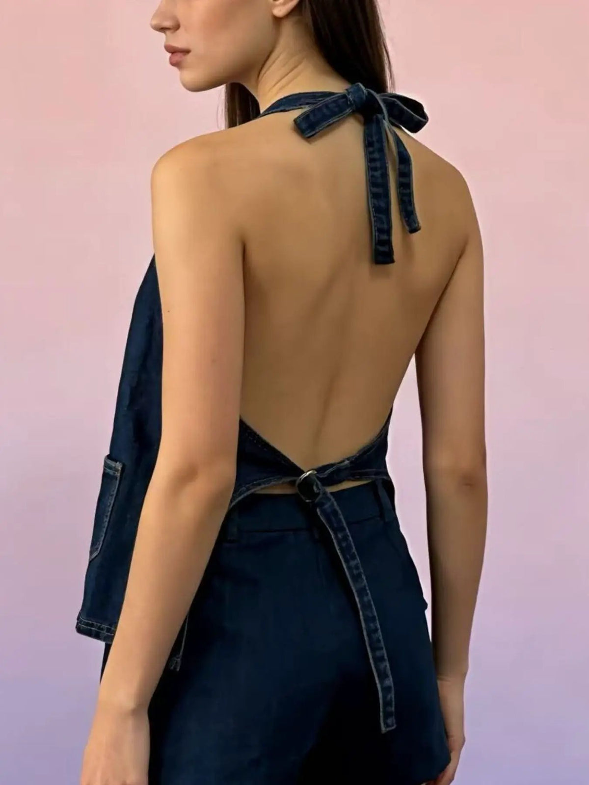 Halter-neck denim vest with button front and adjustable tie closure in dark indigo (back view)