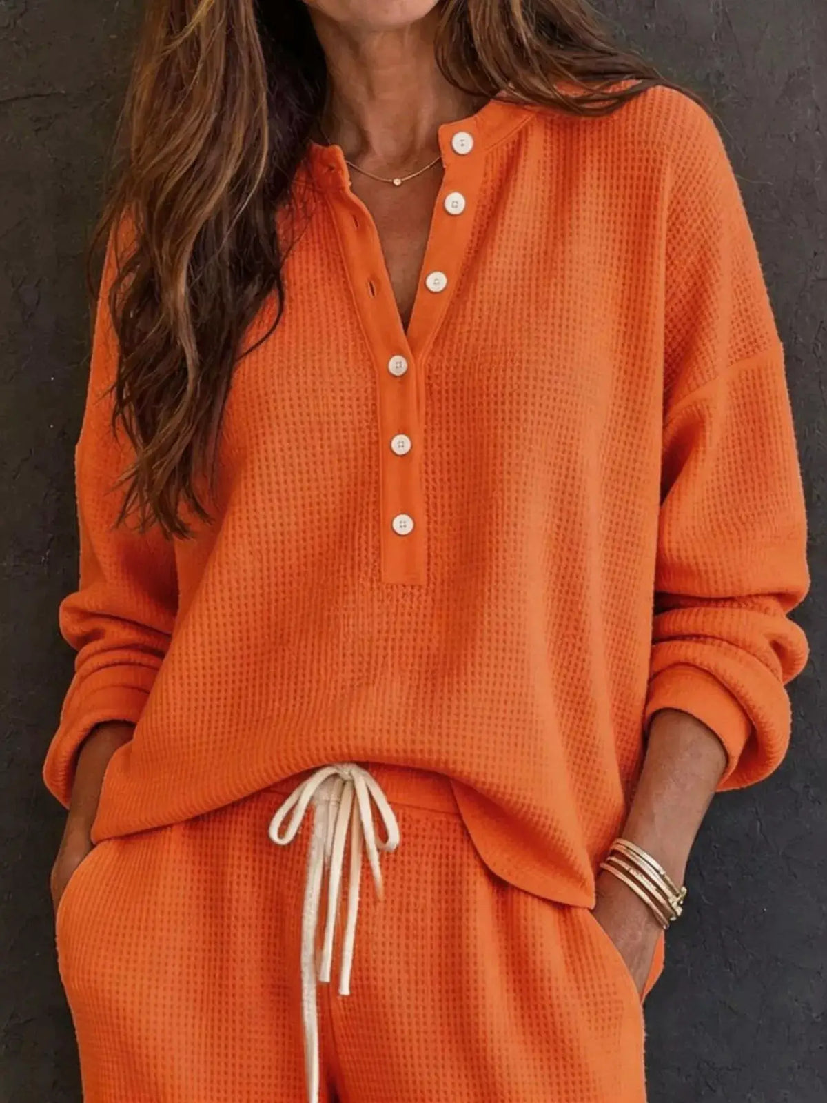 Waffle-knit Henley top and wide-leg pants set in orange; Trendsi loungewear with button placket and drawstring waist.